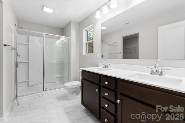 a bathroom with a double vanity sink toilet and a mirror