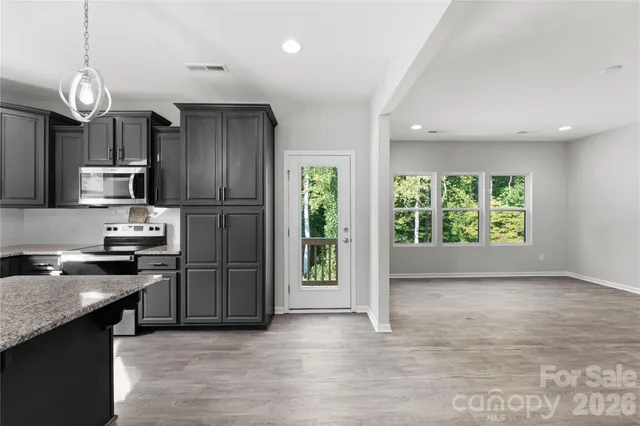 a kitchen with granite countertop stainless steel appliances and wooden cabinets