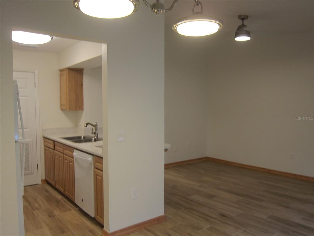 7023 Southwest 21st Lane Gainesville, FL 32607 - Photo 3 of 27 a view of a kitchen with a sink wooden floor and cabinets