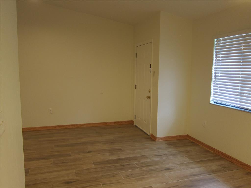 7023 Southwest 21st Lane Gainesville, FL 32607 - Photo 4 of 27 a view of an empty room with wooden floor and a window