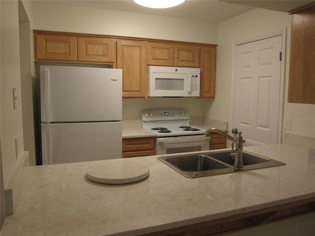 7023 Southwest 21st Lane Gainesville, FL 32607 - Photo 8 of 27 a kitchen with a sink a refrigerator and cabinets