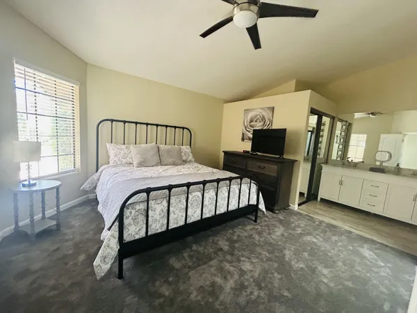 a bedroom with a bed window and a flat screen tv