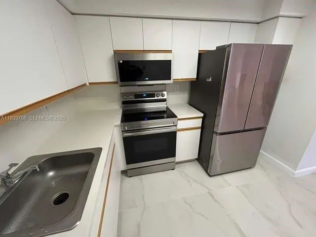 a kitchen with a refrigerator and a stove