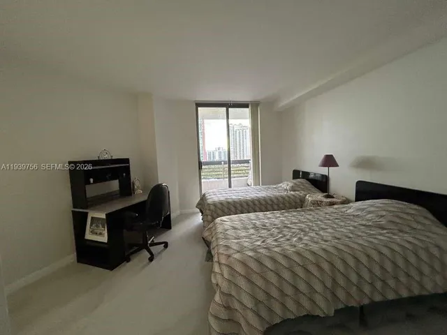 a bedroom with two beds and chair