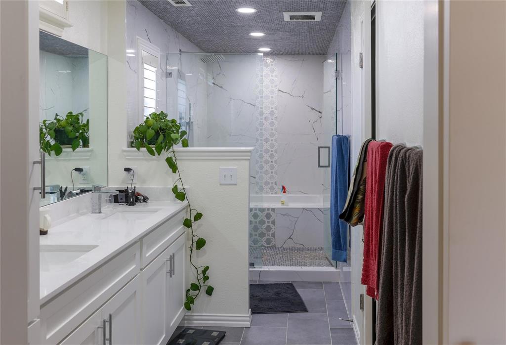 224 Sovereign Court Rockwall, TX 75032 - Photo 10 of 16 a bathroom with a sink a mirror and a shower