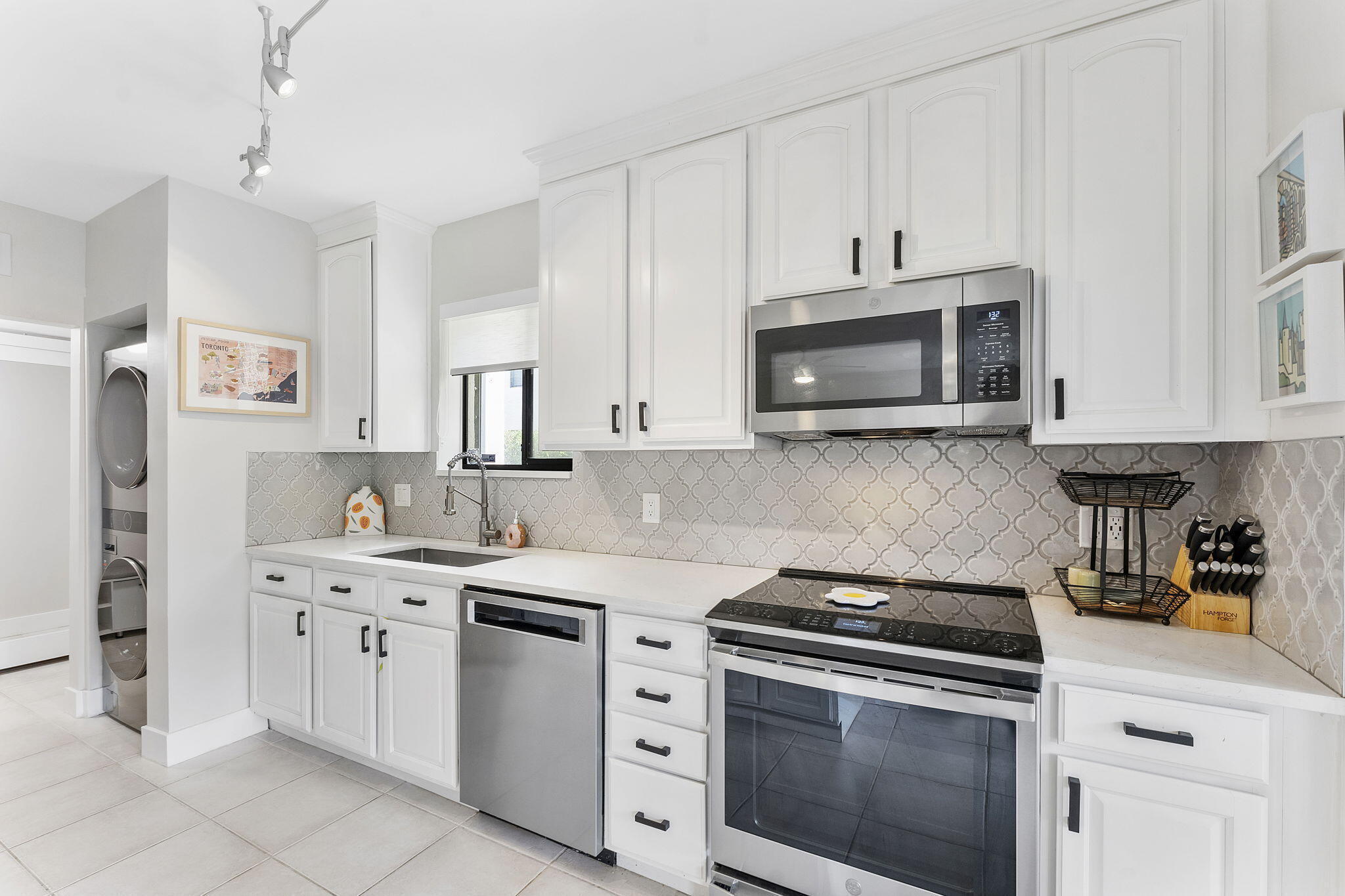 6314 Longboat Lane West, Unit A102 Boca Raton, FL 33433 - Photo 4 of 24 a kitchen with white cabinets and appliances