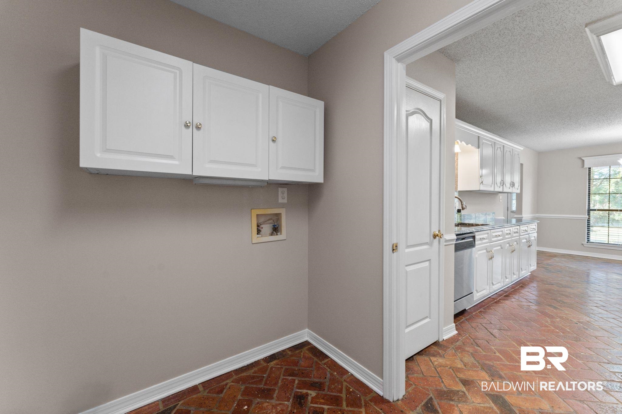 888 Mobile Cut-Off Road St. Stephens, AL 36569 - Photo 17 of 54 Laundry area with brick floors, a textured ceiling, washer hookup, and cabinet space