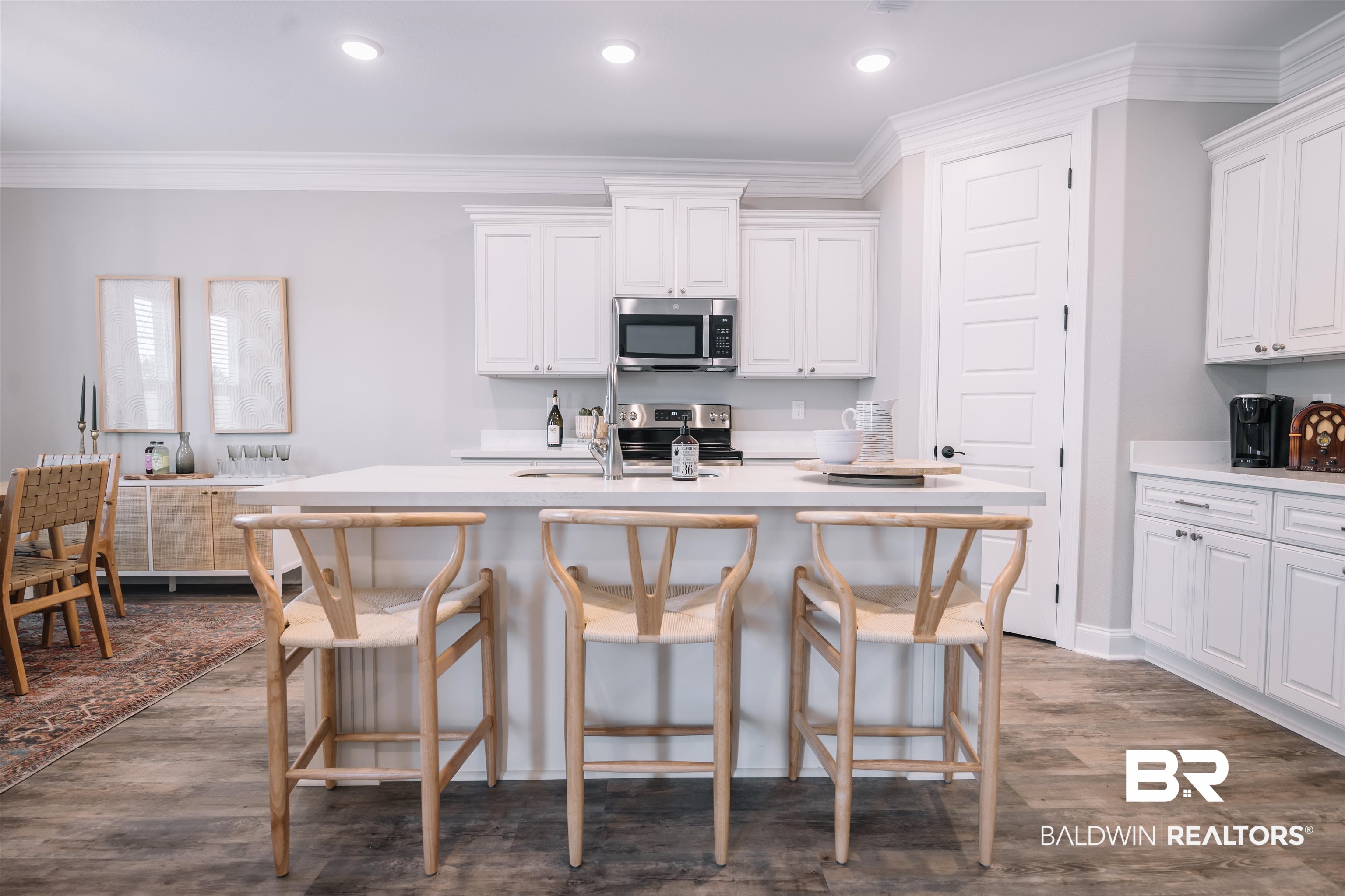 12894 Flanagan Street Elberta, AL 36530 - Photo 12 of 29 Kitchen with a kitchen island with sink, white cabinets, stainless steel appliances, and hardwood / wood-style flooring