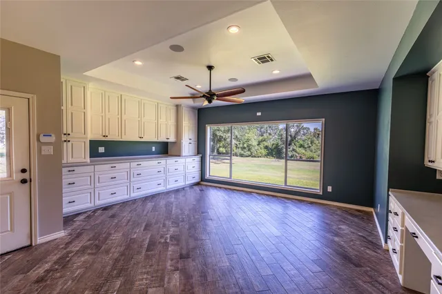 a view of a kitchen with wooden floor and a window