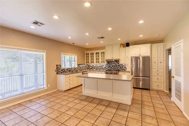 a kitchen with stainless steel appliances granite countertop a refrigerator and a sink