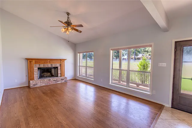 wooden floor fireplace and windows in an empty room
