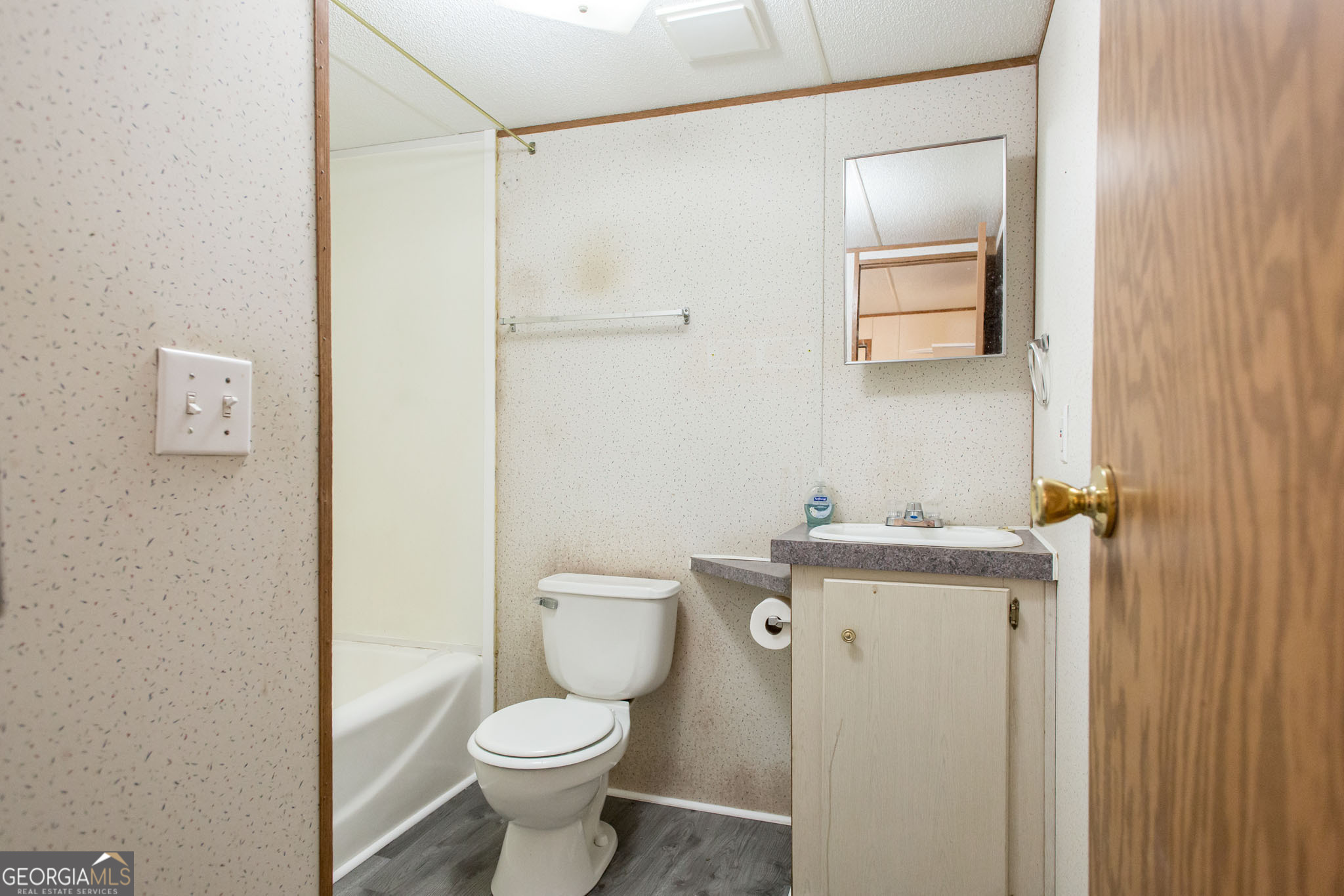 6005 Chancey Road Patterson, GA 31557 - Photo 14 of 23 a bathroom with a granite countertop toilet a sink and a mirror