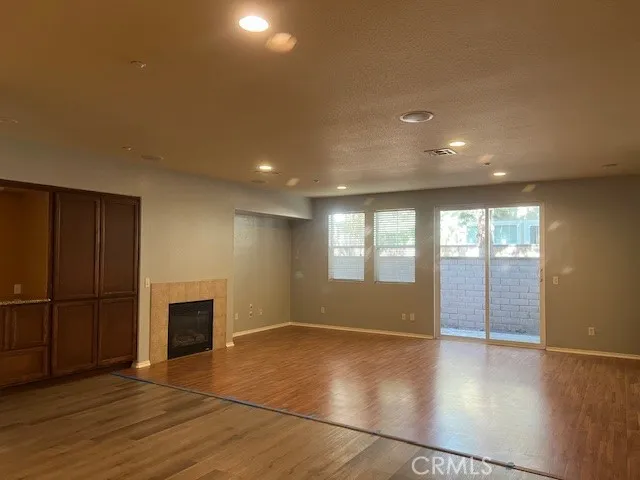 an empty room with wooden floor and a fireplace