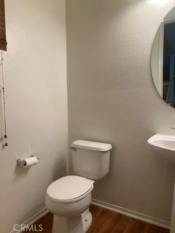 a white toilet sitting next to a white wall
