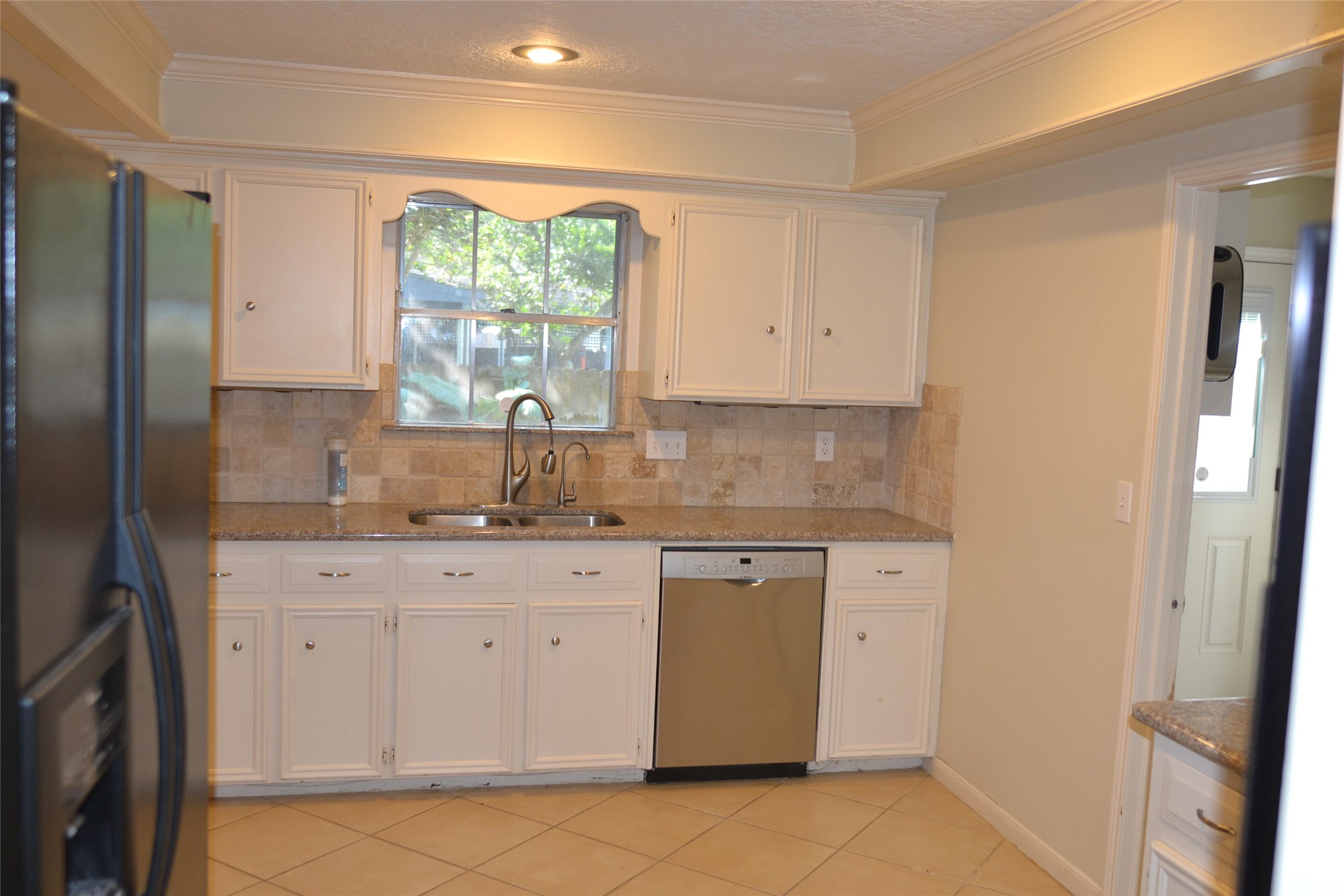 1223 Longledge Drive Seabrook, TX 77586 - Photo 19 of 49 a kitchen with granite countertop white cabinets white appliances a sink and a window