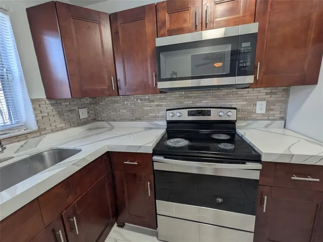 a white refrigerator freezer and a stove sitting inside of a kitchen
