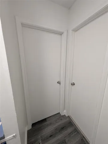 an empty room with wooden floor and window