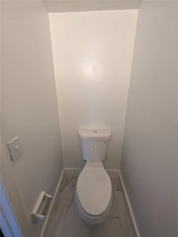 a white toilet sitting in a bathroom next to a sink