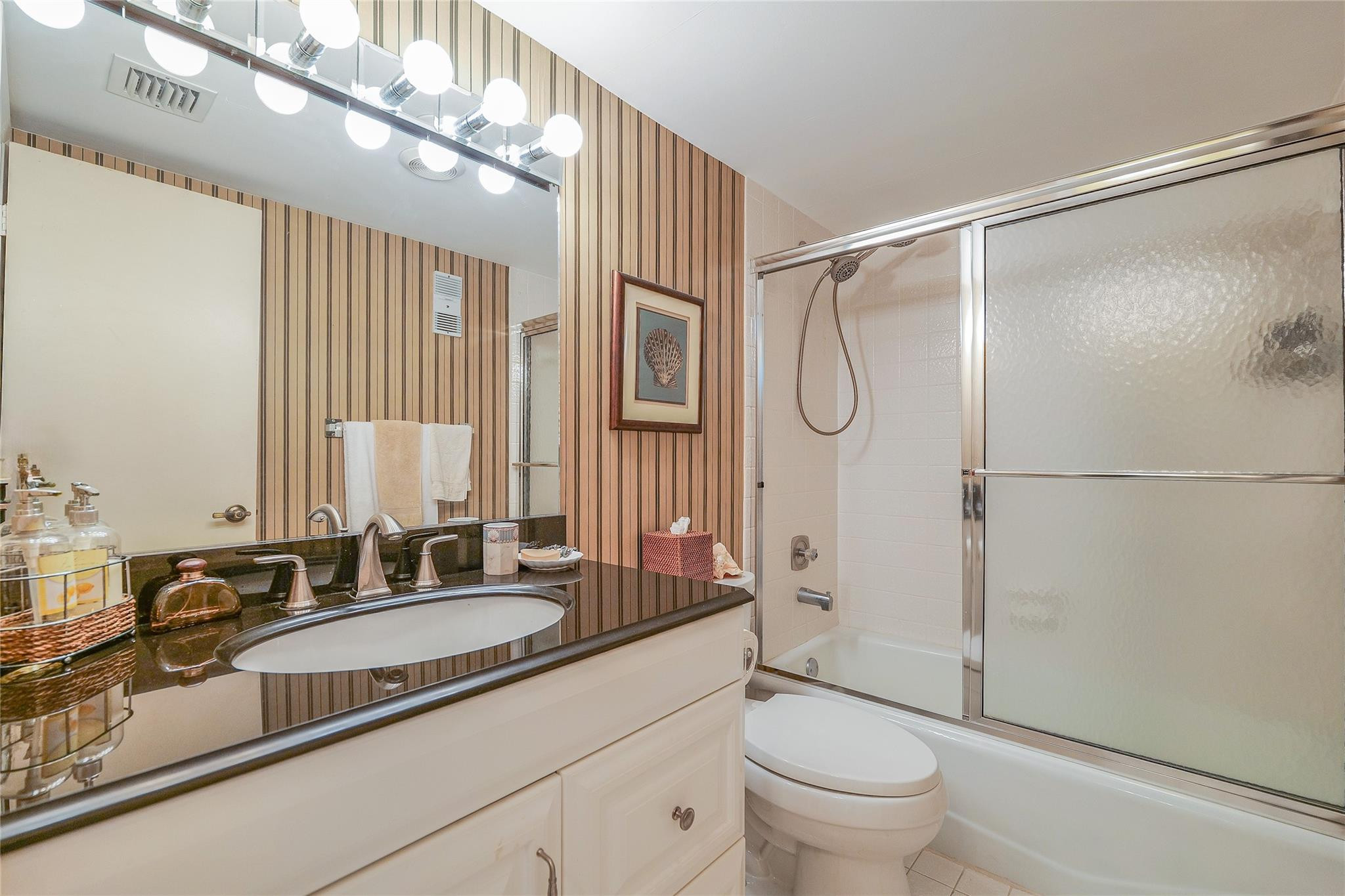 3930 Inverrary Boulevard, Unit 608D Lauderhill, FL 33319 - Photo 28 of 65 a bathroom with a granite countertop sink a toilet and shower