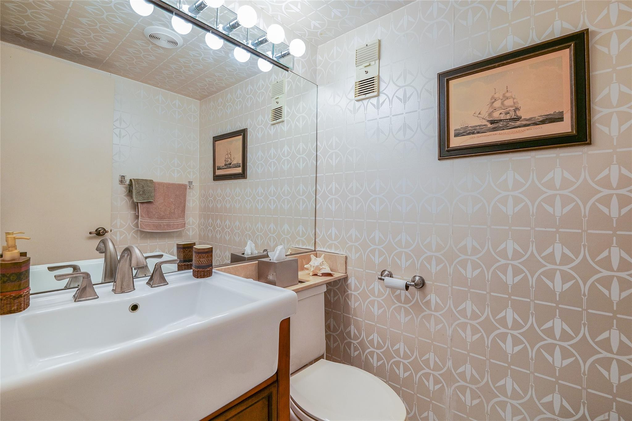 3930 Inverrary Boulevard, Unit 608D Lauderhill, FL 33319 - Photo 36 of 65 a bathroom with a toilet a sink and mirror