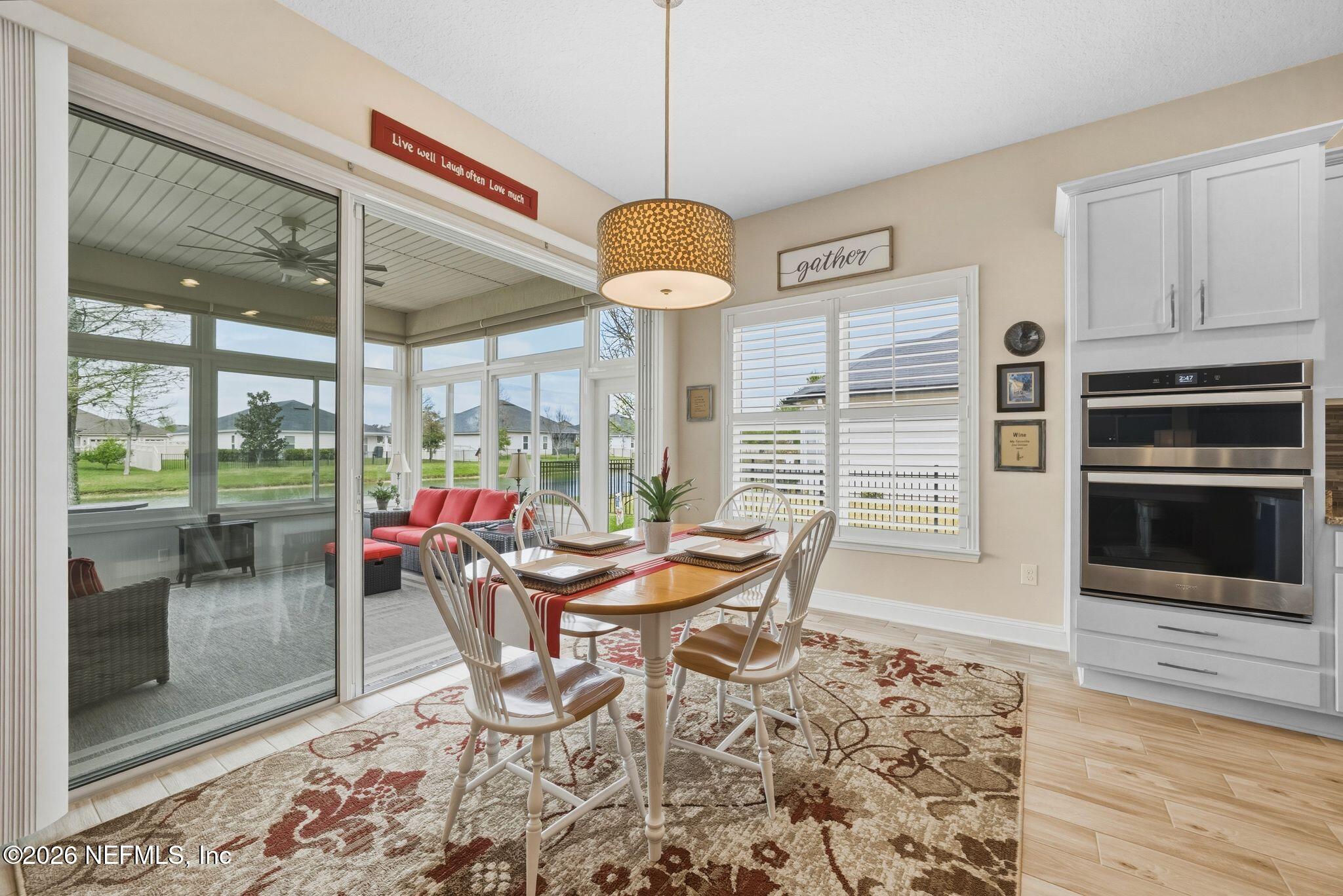 334 Athens Drive St. Augustine, FL 32092 - Photo 12 of 57 a dining room with wooden floor and a chandelier