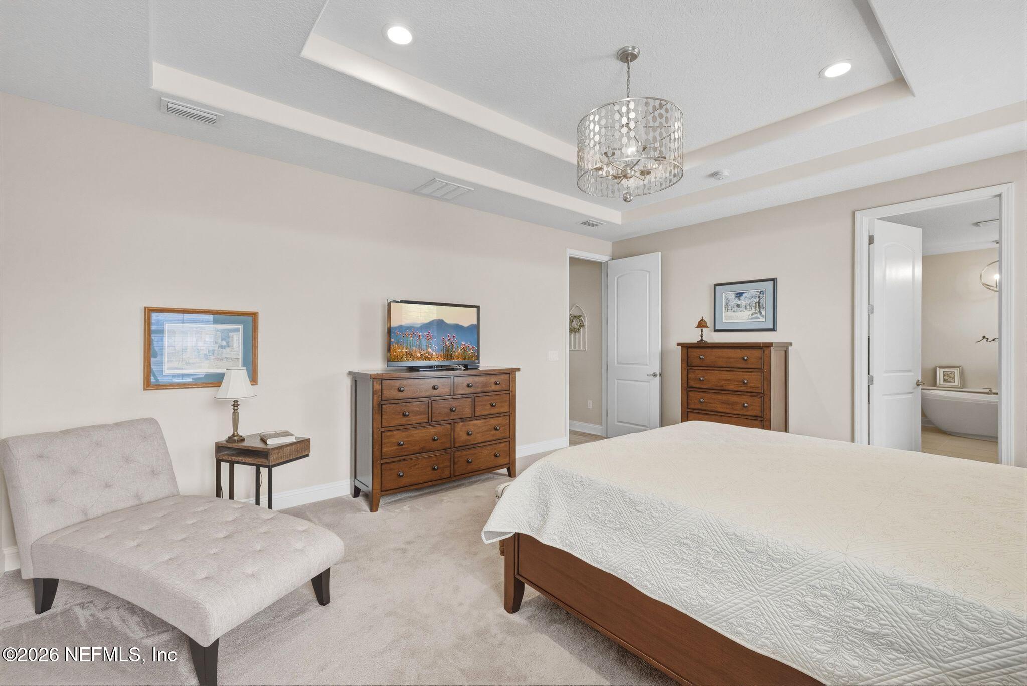 334 Athens Drive St. Augustine, FL 32092 - Photo 16 of 57 a spacious bedroom with a bed and a chandelier