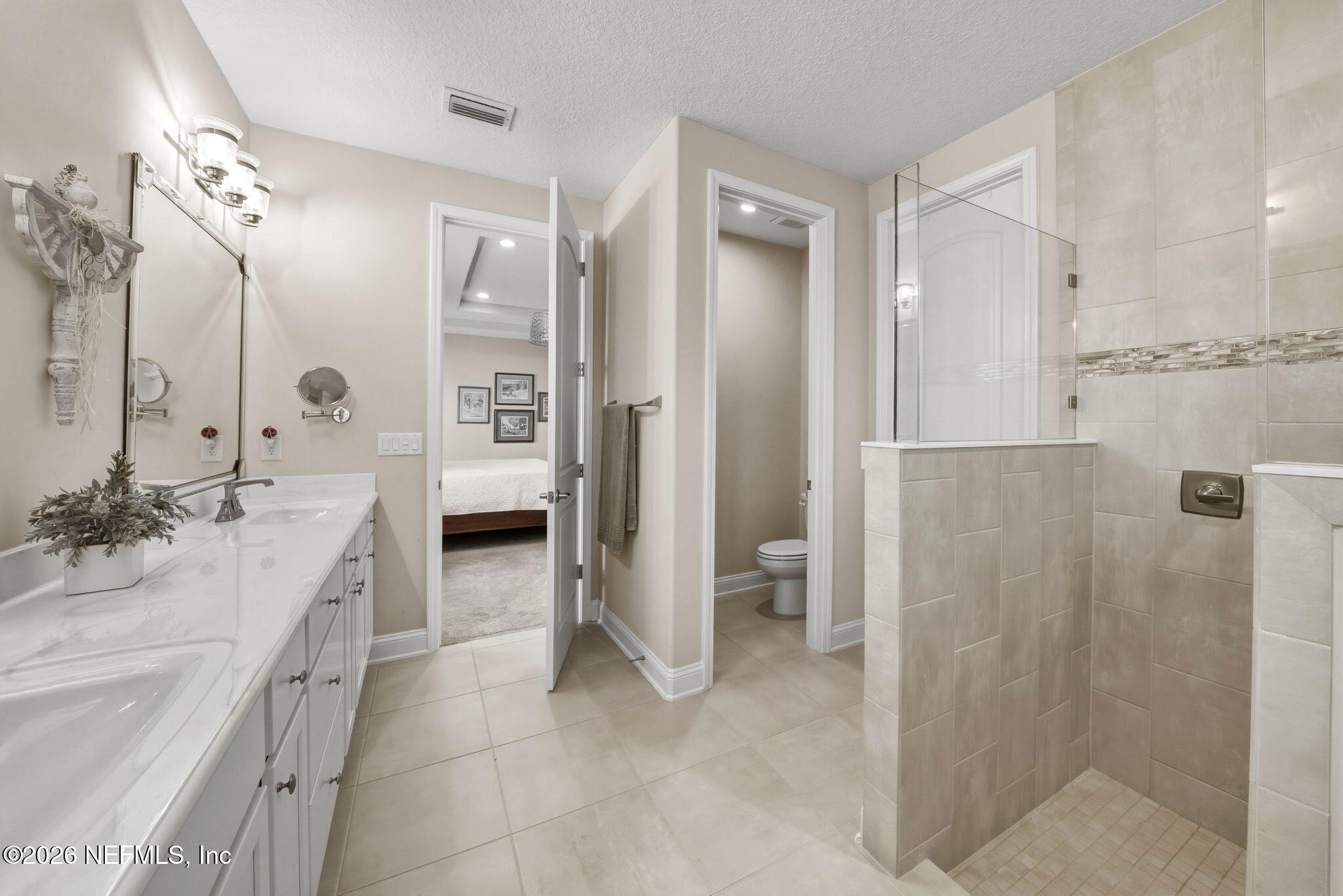 334 Athens Drive St. Augustine, FL 32092 - Photo 20 of 57 a spacious bathroom with a double vanity sink a large mirror and a shower