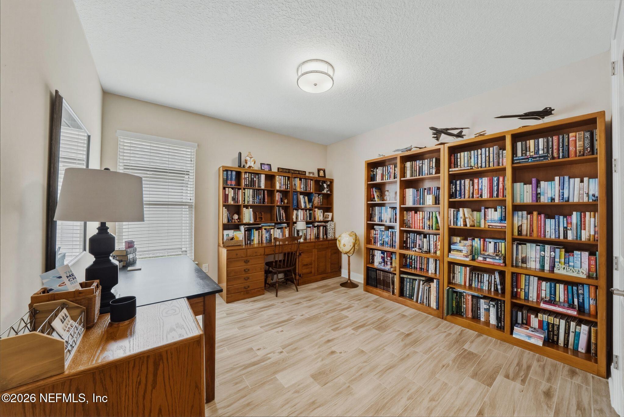 334 Athens Drive St. Augustine, FL 32092 - Photo 21 of 57 a living room with a book shelf and a wooden floor