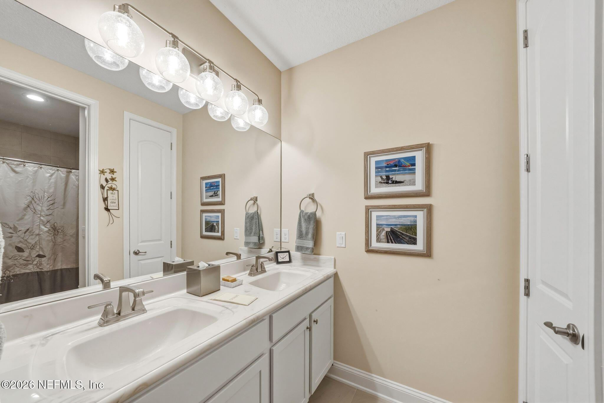 334 Athens Drive St. Augustine, FL 32092 - Photo 25 of 57 a bathroom with a sink vanity and a mirror