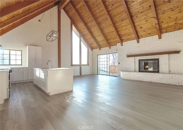 a view of a livingroom with wooden floor and a fireplace
