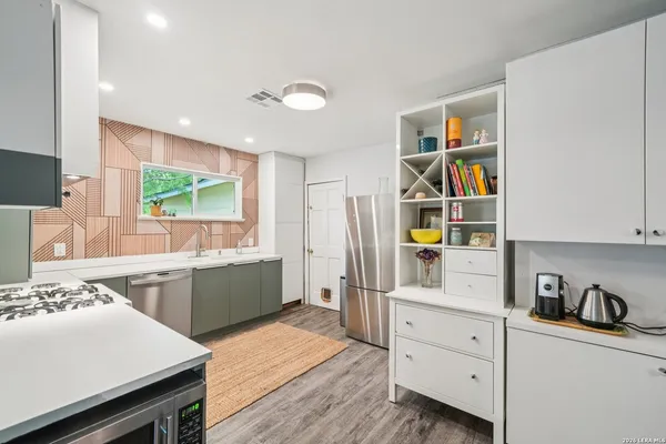 a kitchen with stainless steel appliances a stove a sink and a refrigerator
