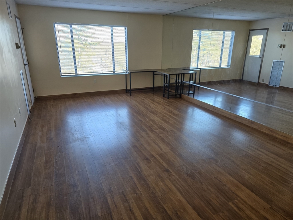1550 Worcester Road, Unit 414B Framingham, MA 01702 - Photo 3 of 8 an empty room with wooden floor and windows