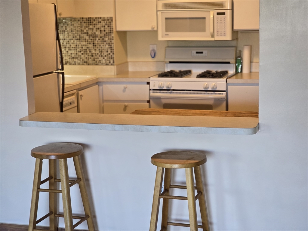 1550 Worcester Road, Unit 414B Framingham, MA 01702 - Photo 5 of 8 a kitchen with a stove and a microwave