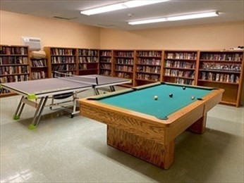 1550 Worcester Road, Unit 414B Framingham, MA 01702 - Photo 7 of 8 a living room with furniture pool table and book shelf