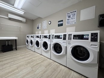 1550 Worcester Road, Unit 414B Framingham, MA 01702 - Photo 8 of 8 a utility room with dryer washer and view of living room