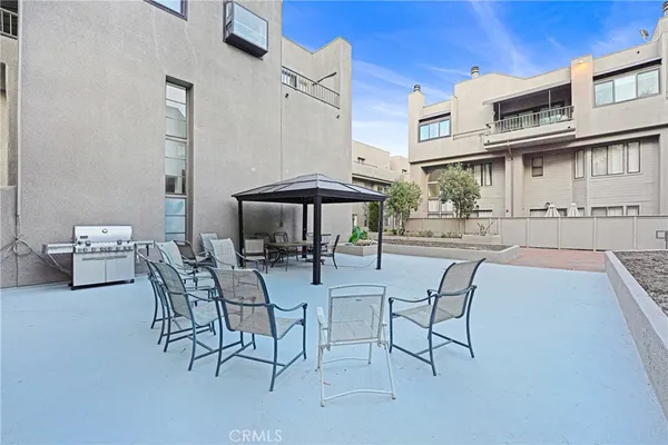 a view of a patio with dining table and chairs