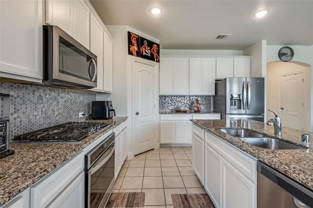 a kitchen with a sink stove top oven and refrigerator