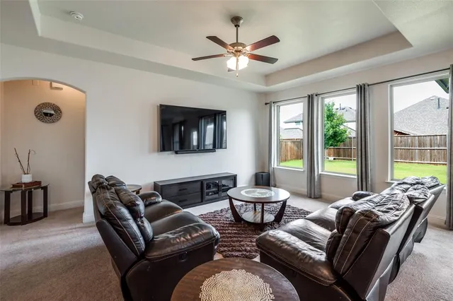 a living room with furniture ceiling fan and a window