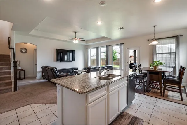 a kitchen with a stove a sink a dining table and chairs