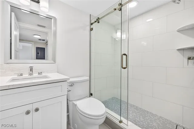 a bathroom with a granite countertop sink toilet and shower