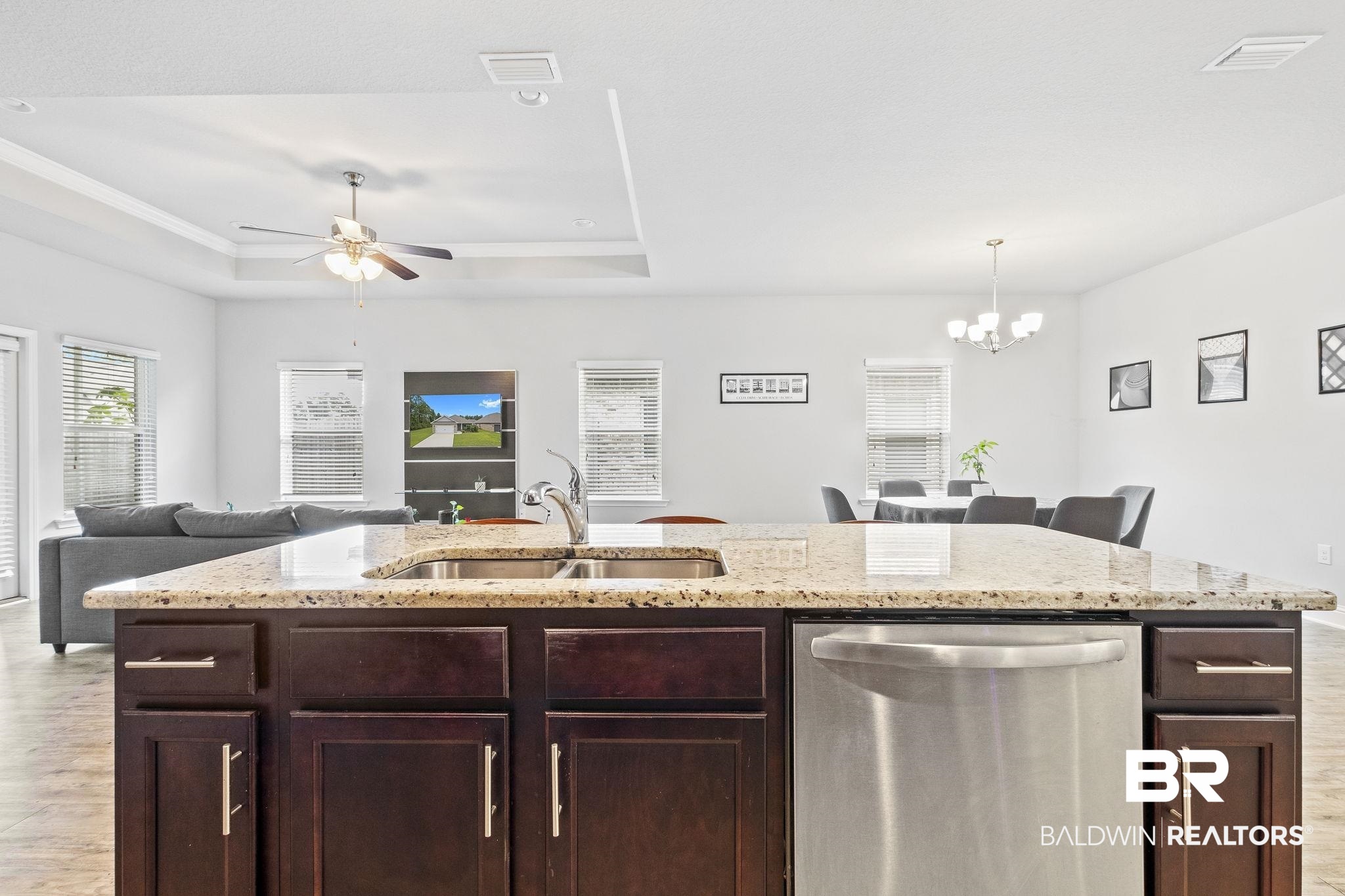 31643 Kestrel Loop Daphne, AL 36527 - Photo 13 of 59 Kitchen with ceiling fan with notable chandelier, dark brown cabinets, sink, a tray ceiling, and stainless steel dishwasher