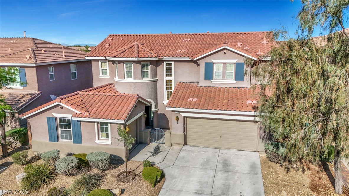 10328 Hawk Ravine Street Las Vegas, NV 89178 - Photo 55 of 55 A well-maintained residence boasts an attached garage and desert landscaping, offering appealing curb appeal.