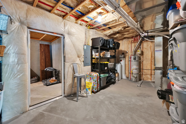 1132 South 1300th Street West Mapleton, UT 84664 - Photo 46 of 52 Unfinished storage area with exposed joists and insulation, featuring concrete flooring, a water heater, and an electrical panel
