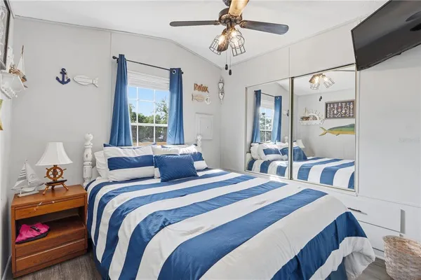 a bedroom with a bed a window and a flat screen television