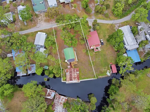 an aerial view of residential houses with outdoor space and lake view