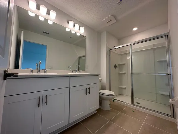 a bathroom with a double vanity sink toilet and shower