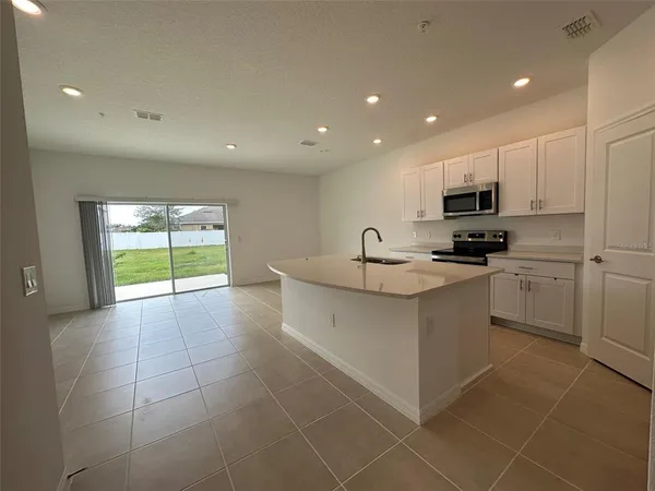 a kitchen with stainless steel appliances a sink stove and cabinets