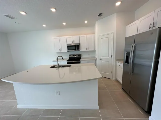 a kitchen with stainless steel appliances a refrigerator sink and microwave