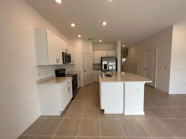 a kitchen with a sink a counter top space cabinets and stainless steel appliances