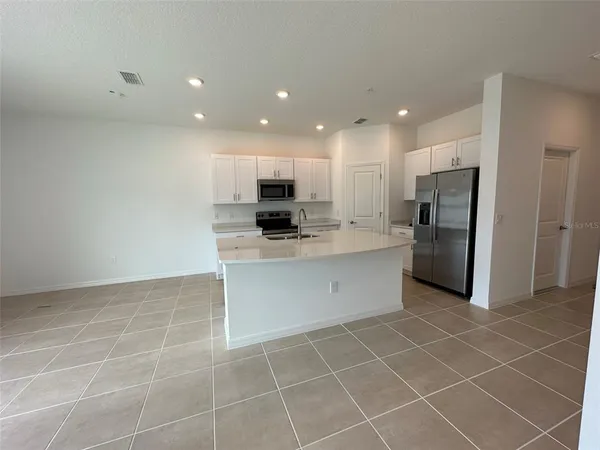 a kitchen with stainless steel appliances a refrigerator sink and microwave